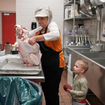 A cafeteria worker prepares a Thanksgiving meal to feed hundreds
